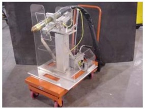 Arc voltage controlled plasma cutting prototype with shielding mounted on a mobile industrial cart.